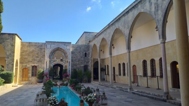 a courtyard with a pool and flowers