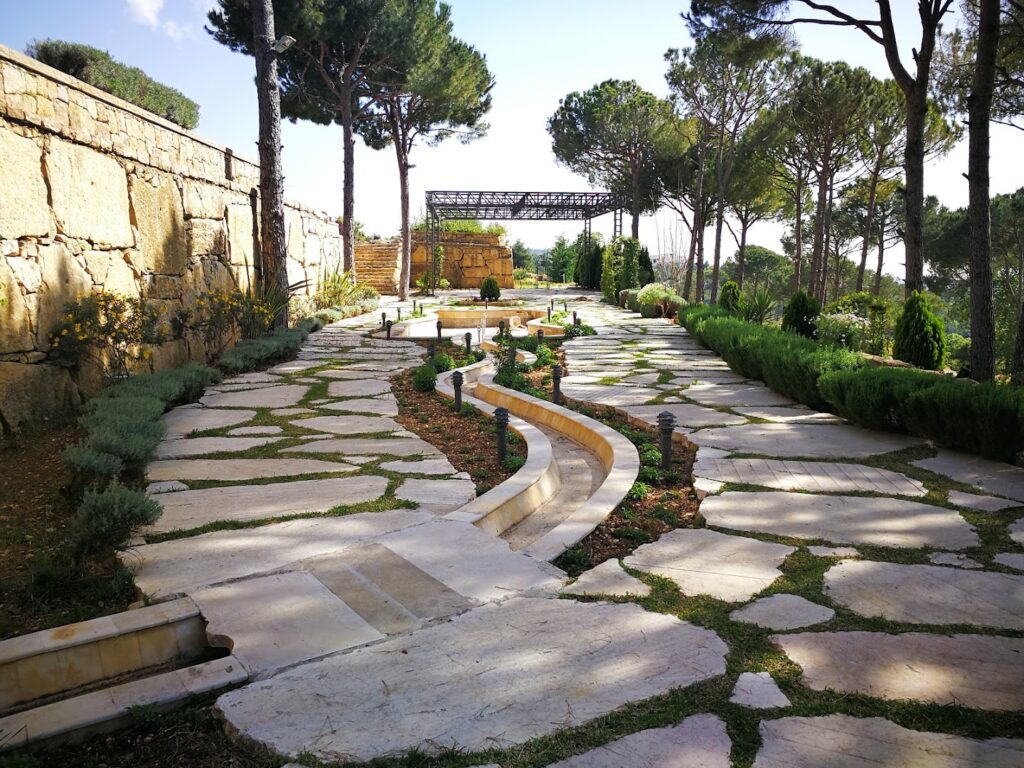 a stone path with a stone wall and trees