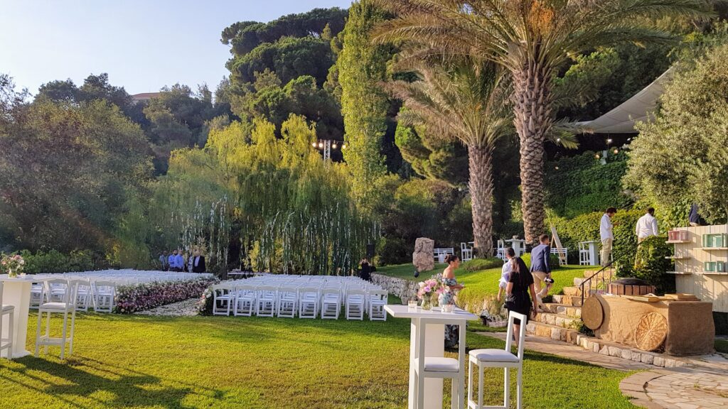 a group of people standing in a park with white chairs and a staircase