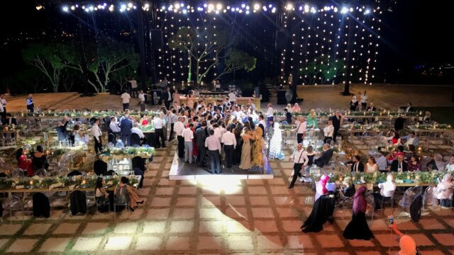 a group of people standing around tables and chairs