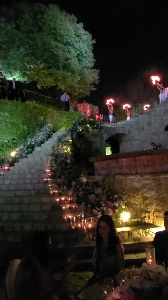 a group of people standing on a stone staircase with candles on them