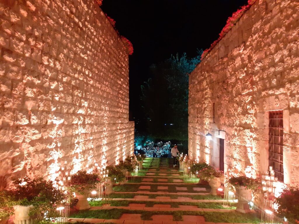 a stone walkway with lights on the side