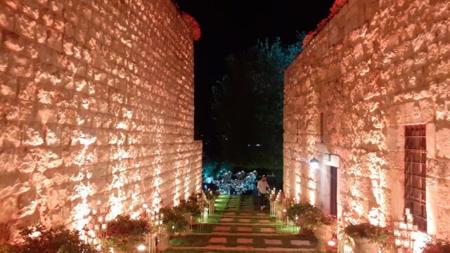 a stone walkway with lights on the side