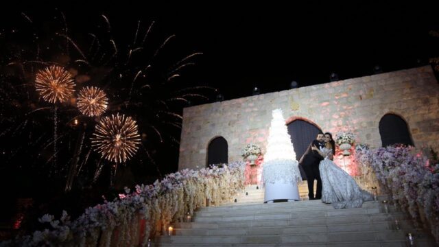 a couple standing on stairs with fireworks in the background