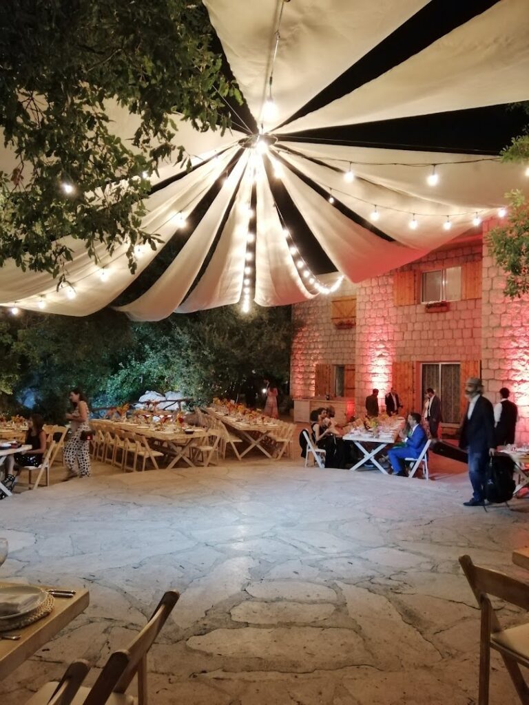 a group of people outside with a tent and tables and chairs