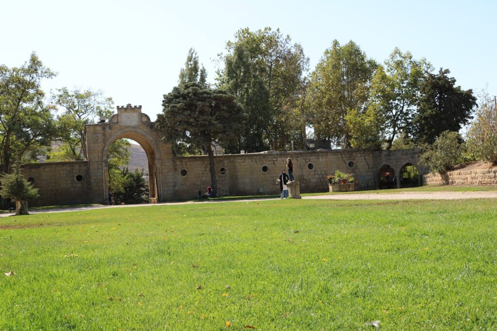 a stone wall with a stone archway and trees