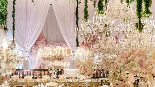 a wedding reception with chandeliers and flowers