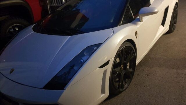 a white sports car parked in a parking lot