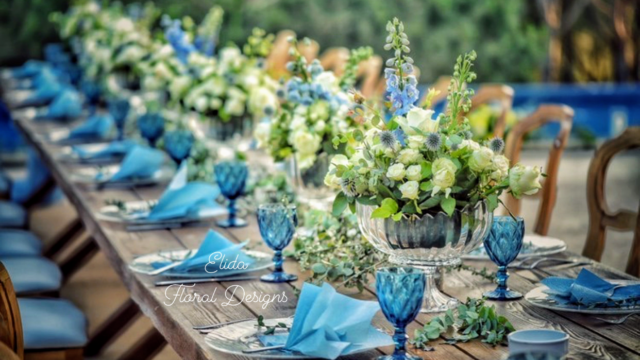 a table with blue glasses and flowers