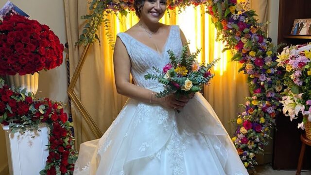 a woman in a wedding dress holding a bouquet of flowers