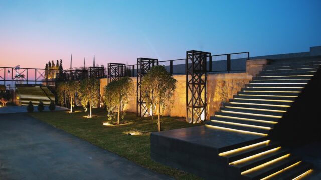 a stone wall with a staircase and trees