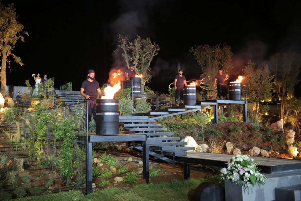 a group of people standing on a set of metal barrels with fire