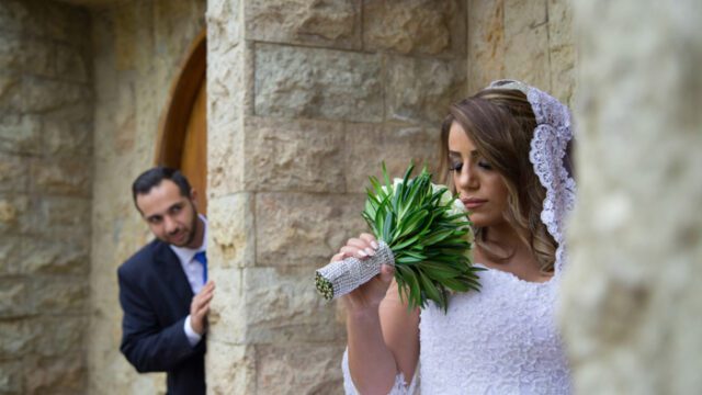 a woman in a wedding dress holding a bouquet of flowers