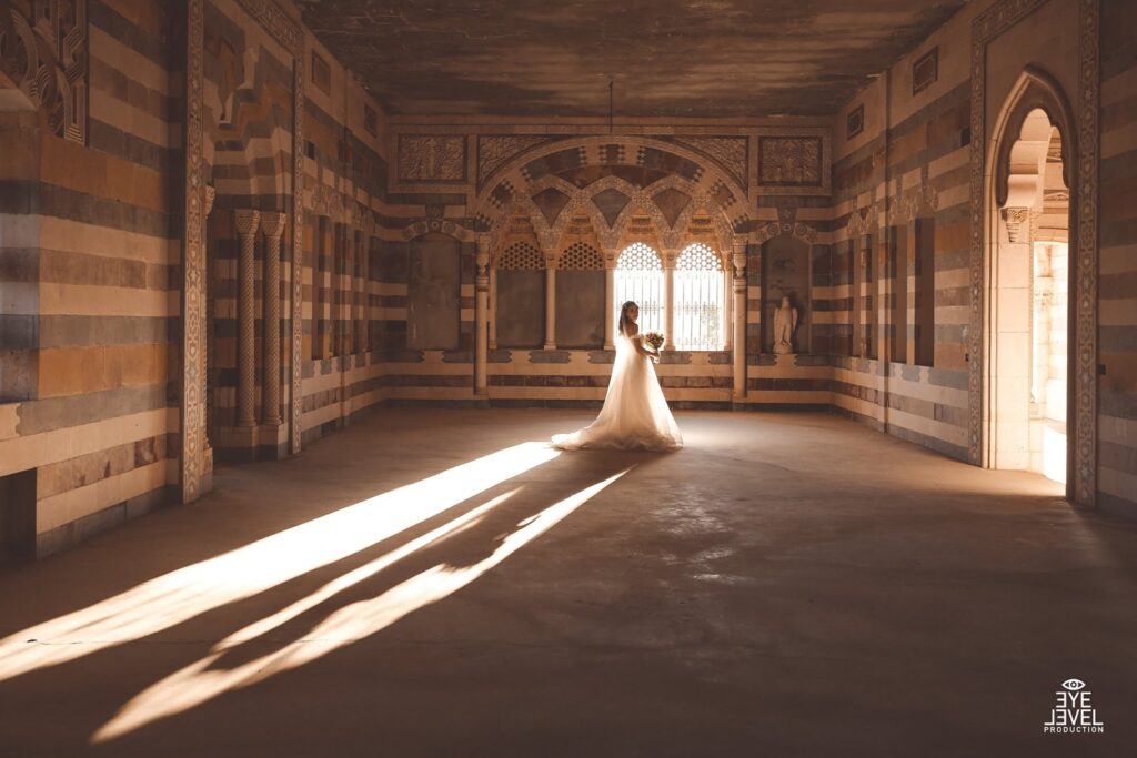a woman in a white dress in a room with columns and arches
