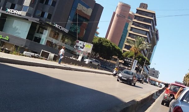 a street with cars and buildings in the background