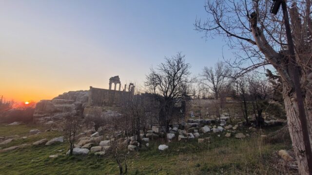 a ruins of a building with rocks and trees