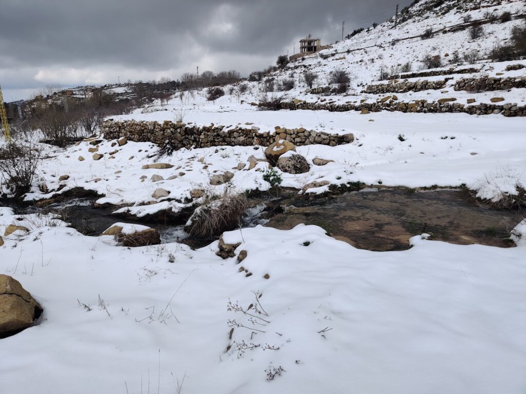 a snowy landscape with a stream