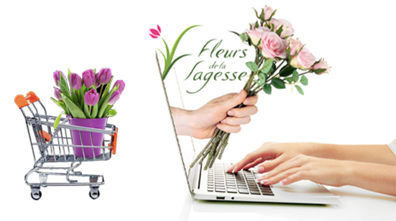 a hand holding flowers next to a laptop