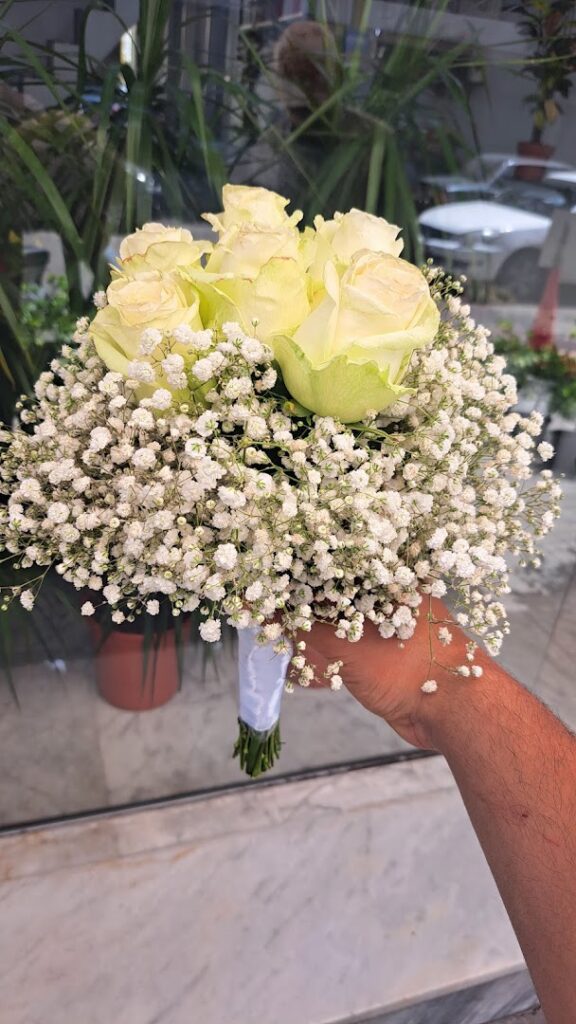 a hand holding a bouquet of white flowers