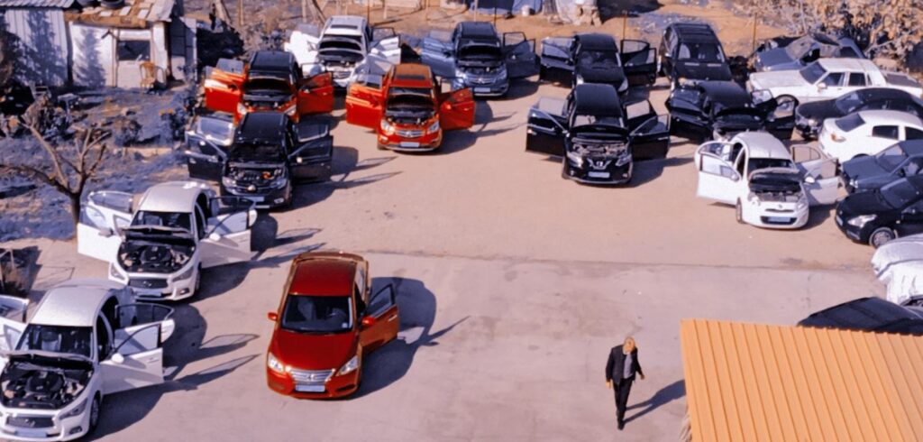 a man walking in a parking lot with cars