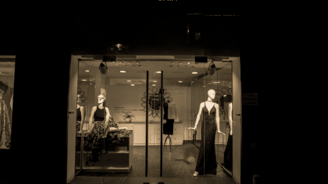 a store front with mannequins in a dress