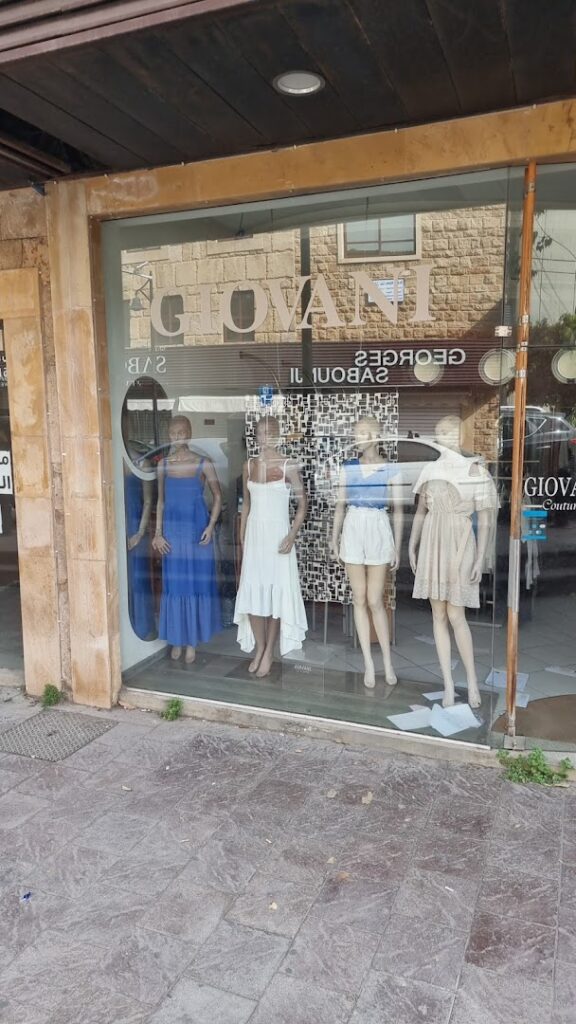 a storefront with mannequins in dresses