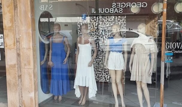 a storefront with mannequins in dresses