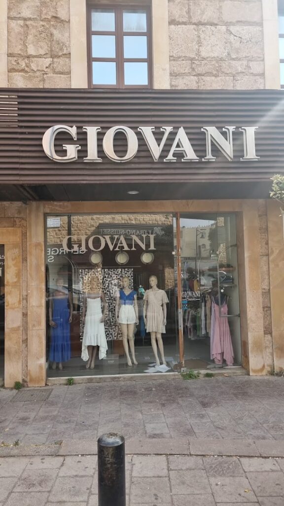 a store front with mannequins in dresses