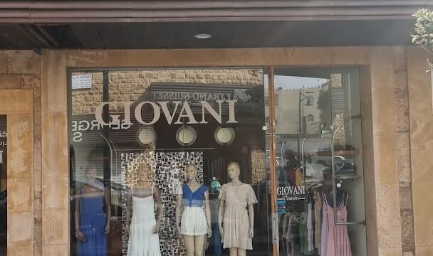 a store front with mannequins in dresses