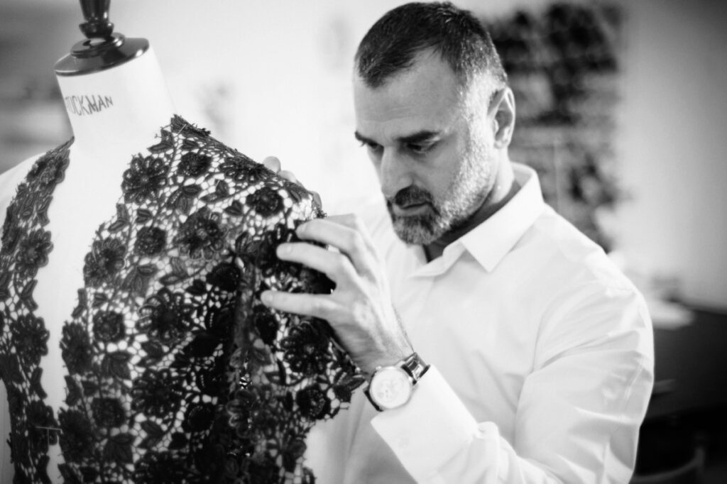 a man looking at a piece of lace on a mannequin