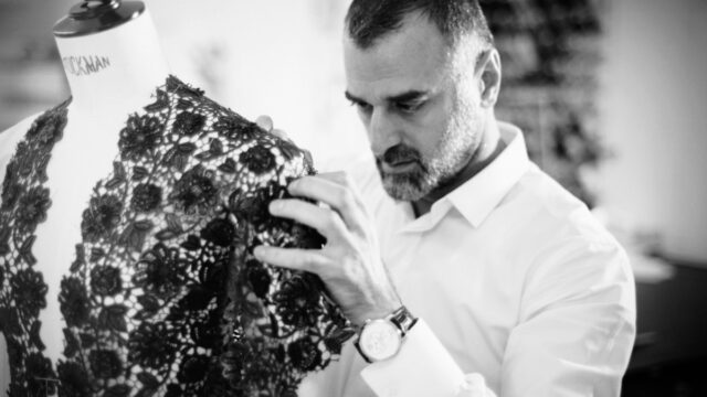 a man looking at a piece of lace on a mannequin