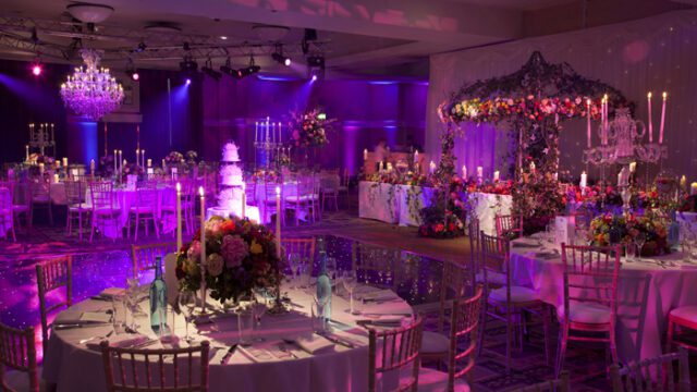 a room with tables and chairs and flowers