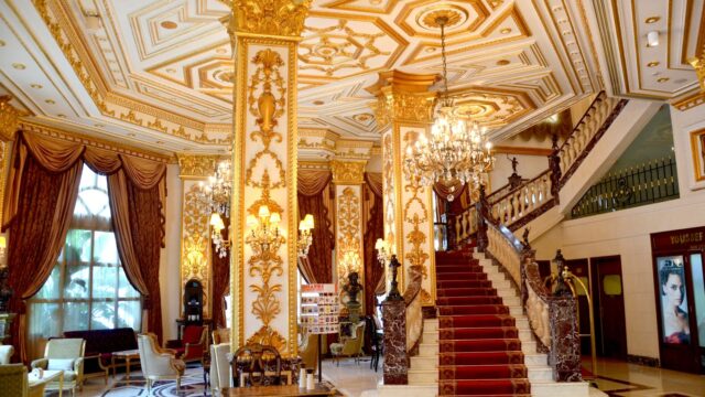 a large ornate building with chandeliers and stairs