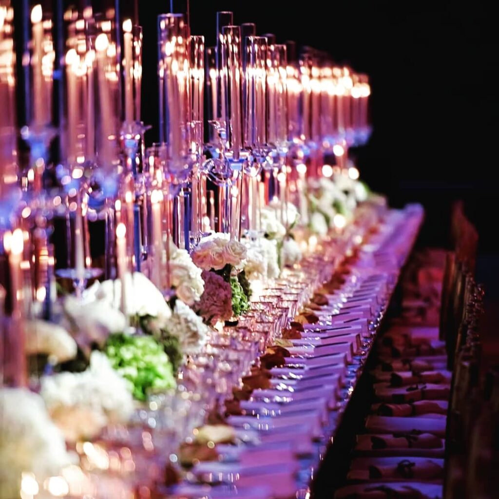 a long table with many glasses and candles