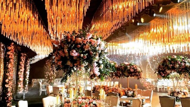 a room with tables and chairs and chandeliers