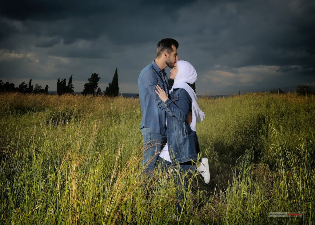 a man and woman kissing in a field