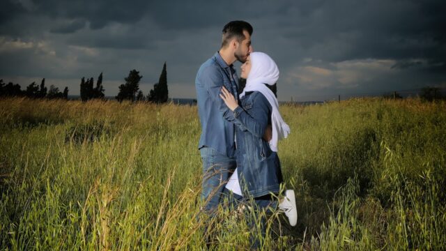 a man and woman kissing in a field