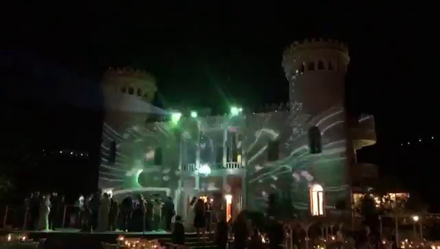 a building with a large castle with lights on
