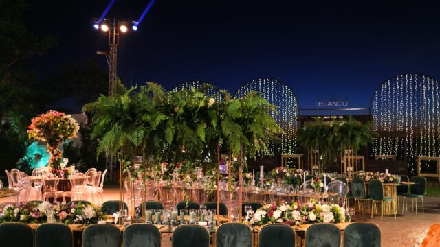 a set up table with chairs and tables with candles and flowers