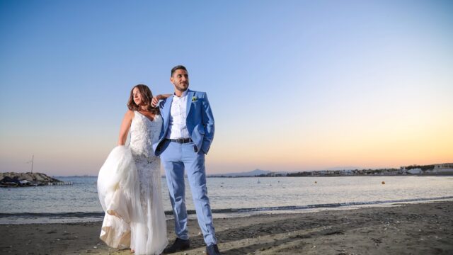 a man and woman posing for a picture on a beach