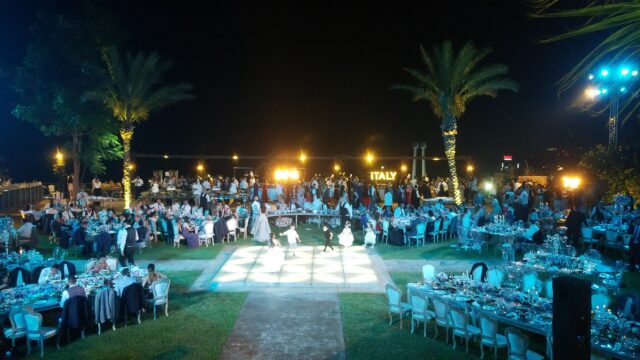 a group of people dancing in a large area with tables and chairs