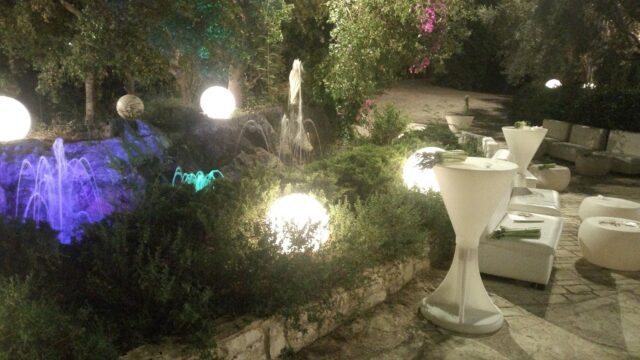 a fountain with lights and tables