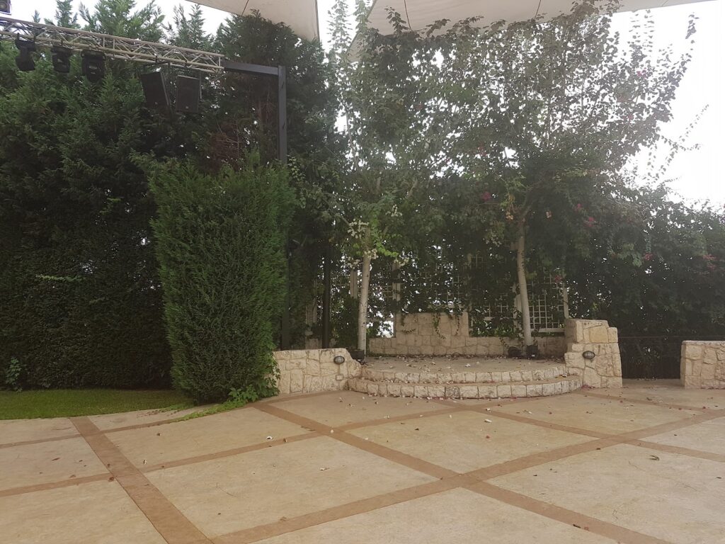 a patio with trees and a stage