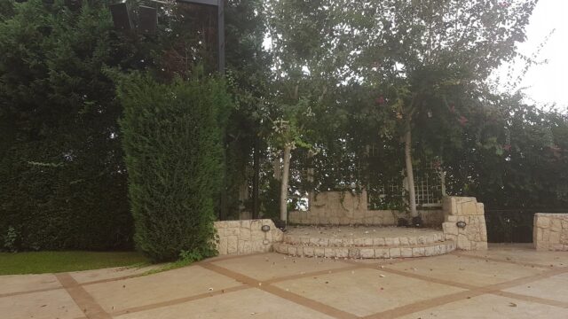 a patio with trees and a stage