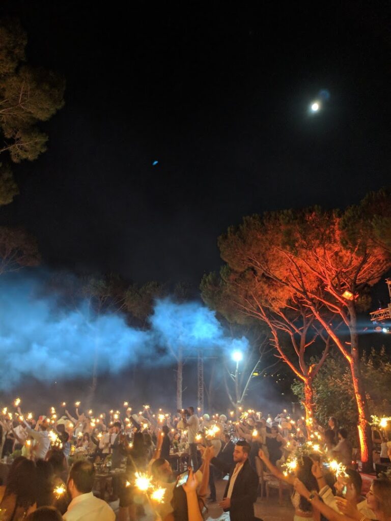 a group of people holding torches and smoke at night