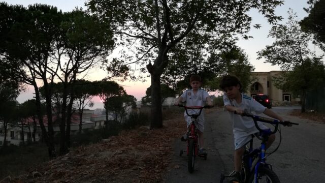 two boys riding bikes on a path