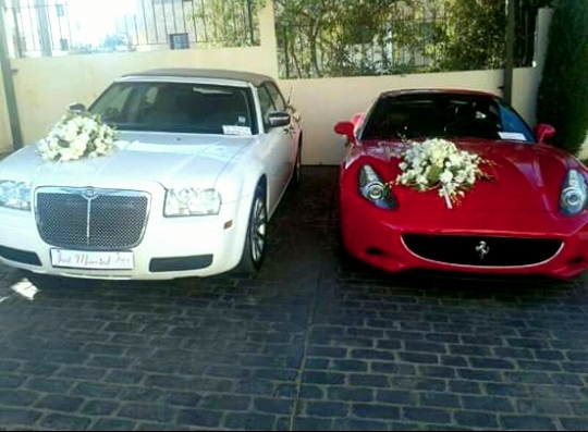 a white car with flowers on the hood and a red car with white flowers on the hood