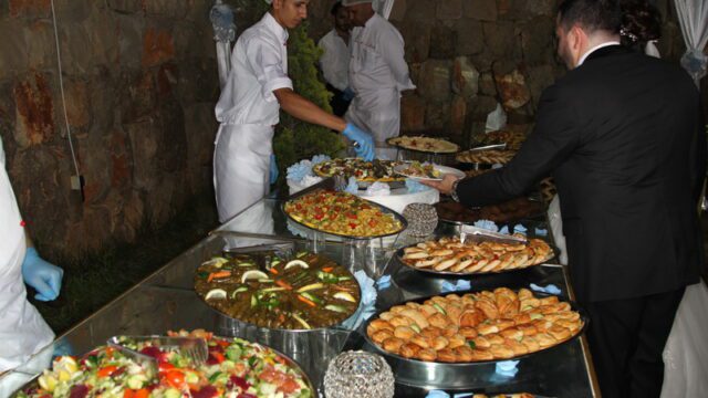 a group of people in white uniforms serving food