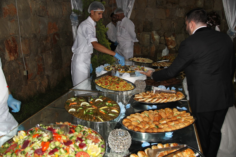 a group of people in white uniforms serving food