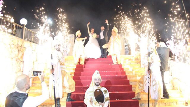 a group of people standing on a red staircase with fireworks